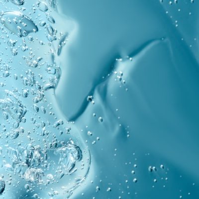 Close up macro Aloe vera gel cosmetic texture blue background with bubbles. Lemongrass gel skincare product. antibacterial liquid with aloe vera, moisturizing. Safe and environmental friendly.